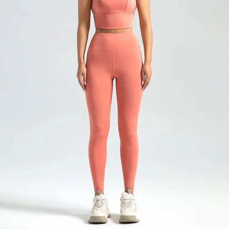 Women's coral high-waist leggings with matching crop top, ideal for yoga and fitness wear