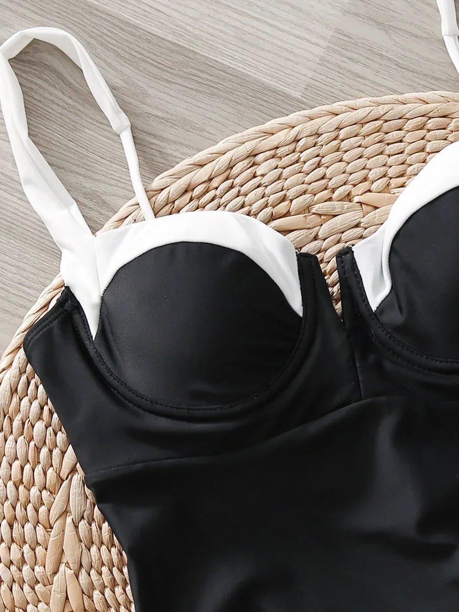 Black and white bikini top with thin straps on woven mat