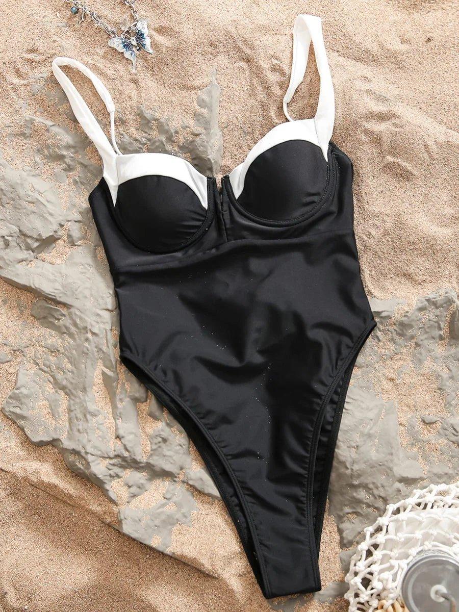 Black and white one-piece swimsuit with underwire bust on sandy beach, beach fashion