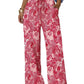 Pink paisley print wide-leg women's pants with drawstring waist, paired with white crop top and sandals