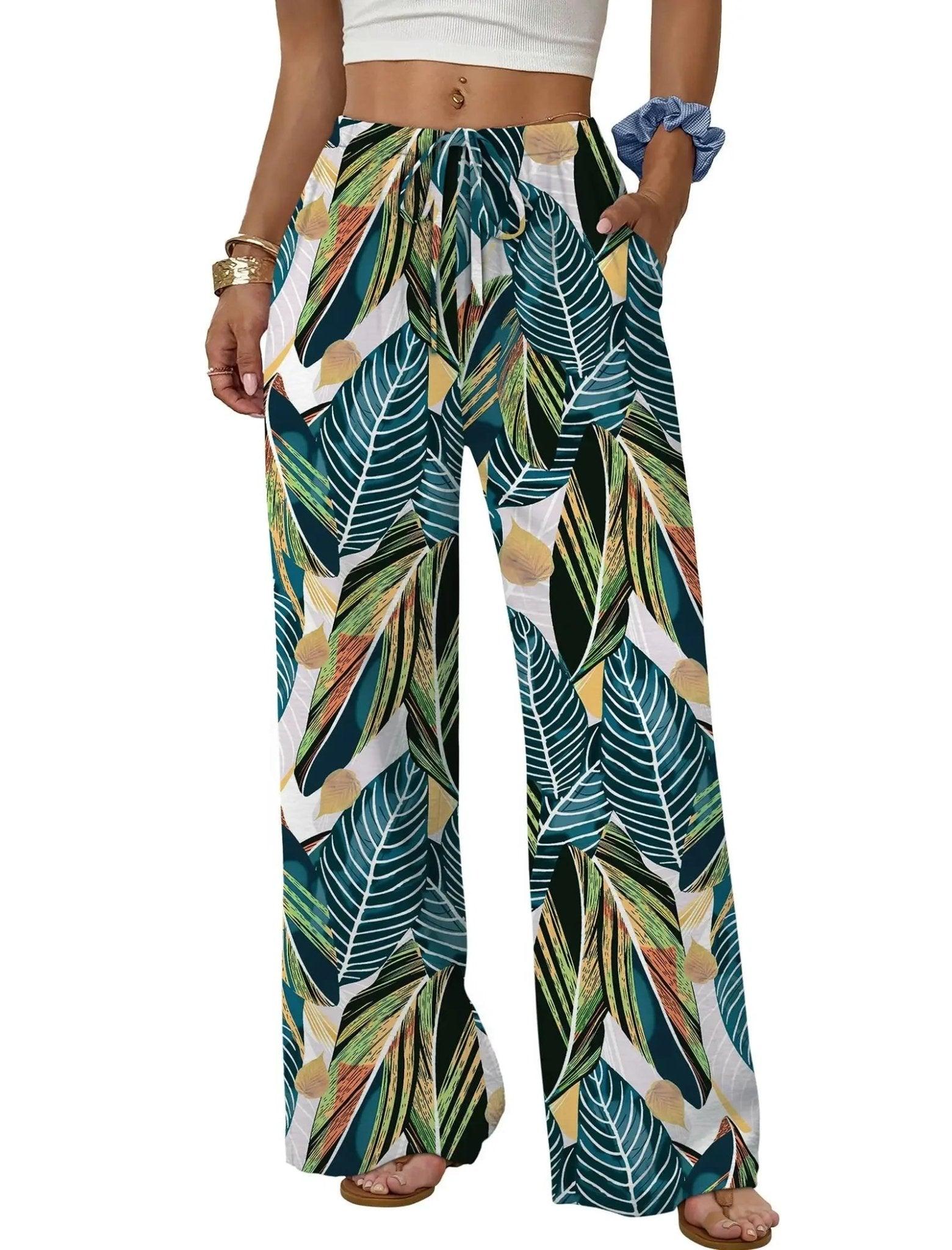 Women's tropical leaf print wide-leg pants with drawstring waist, paired with white crop top and sandals