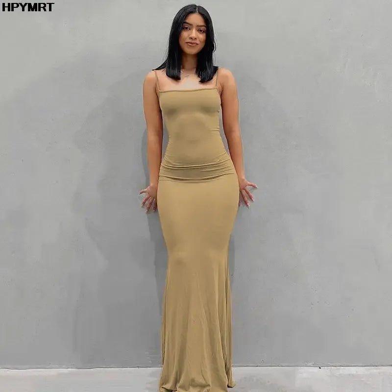Woman in elegant beige spaghetti strap maxi dress, perfect for evening events or fashion-forward looks.