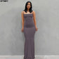Woman in elegant gray maxi dress with thin straps, perfect for evening events or formal occasions.