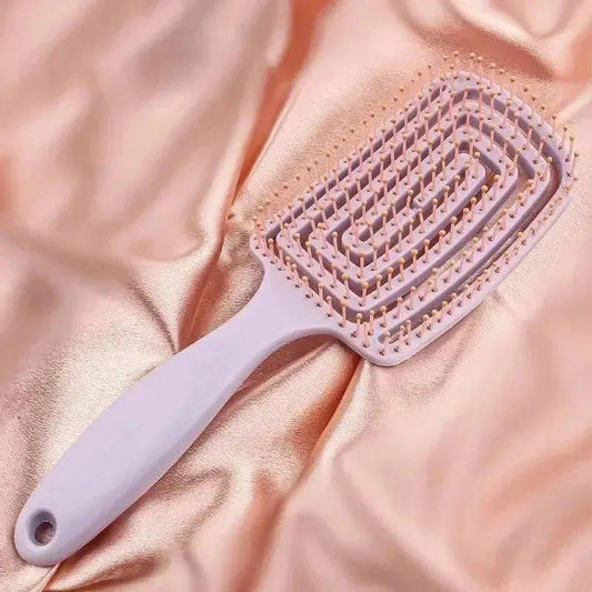 Soft pink detangling hairbrush on satin fabric for gentle hair care