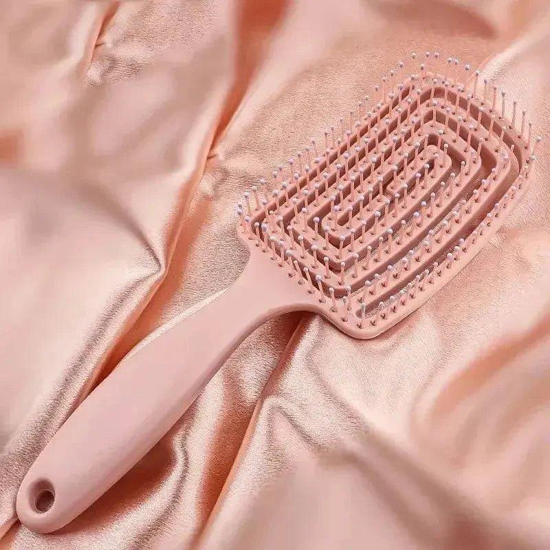 Pink detangling hairbrush on satin fabric for women's beauty and fashion routines