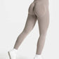 Women's high-waisted seamless leggings with sculpting design, paired with white sneakers for fitness or casual wear.