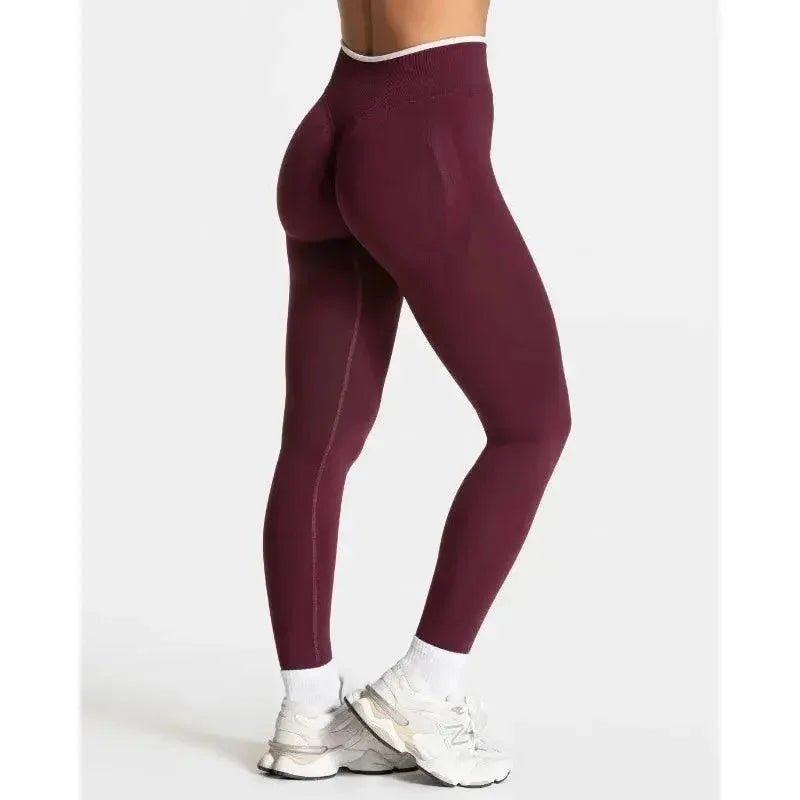 Burgundy high-waisted leggings with white waistband, paired with white sneakers for women's fitness fashion