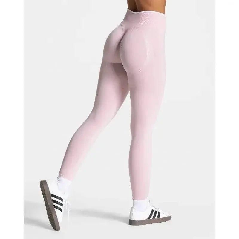 Pink high-waisted leggings with compression fit, paired with white sneakers for women's fashion