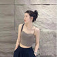 Woman in stylish gray crop top and black pleated pants, modern fashion look