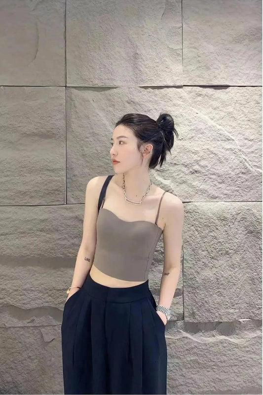 Woman in stylish gray crop top and black pleated pants, modern fashion look