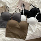 Women's fashion bras in black, white, gray, and olive on a soft bedspread