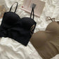 Black and beige strapless bras on white bedding with book, women's fashion lingerie