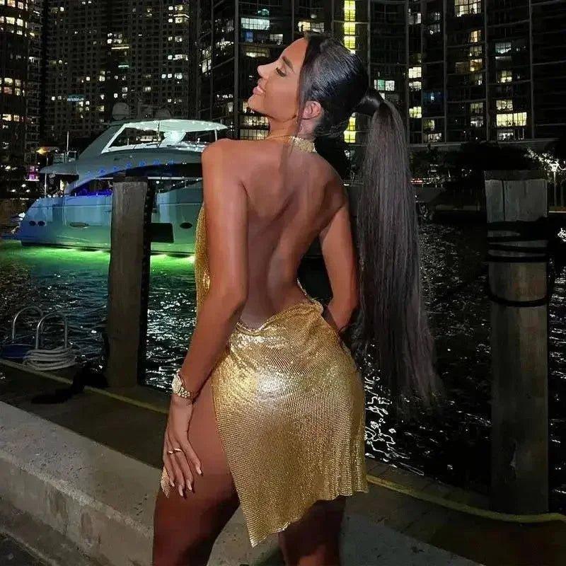 Woman in gold sequin backless dress at night marina, luxury fashion style