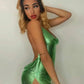Woman in shimmering green sequin dress with high slit, elegant evening fashion