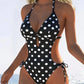 Black and white polka dot one-piece swimsuit with side cutouts and halter neck for women