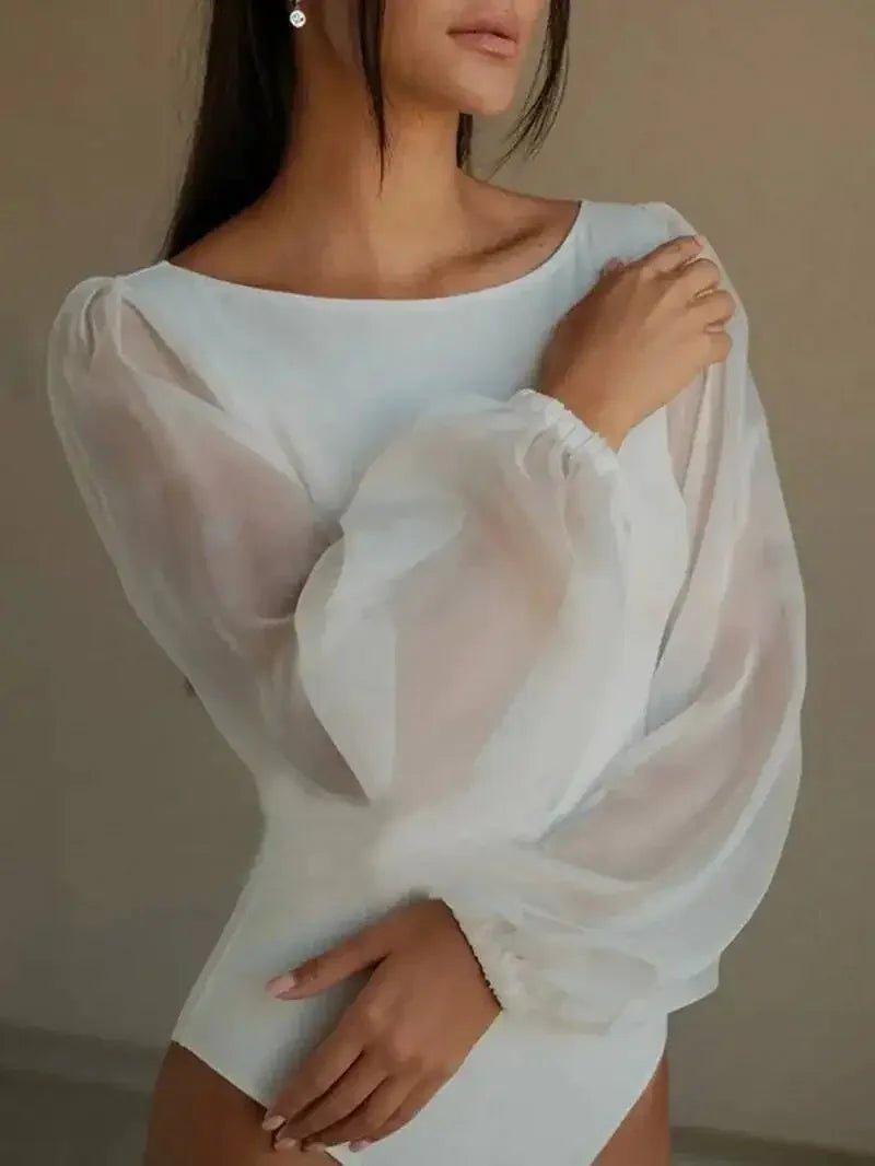 Woman in elegant white off-shoulder blouse with sheer puff sleeves, fashion top