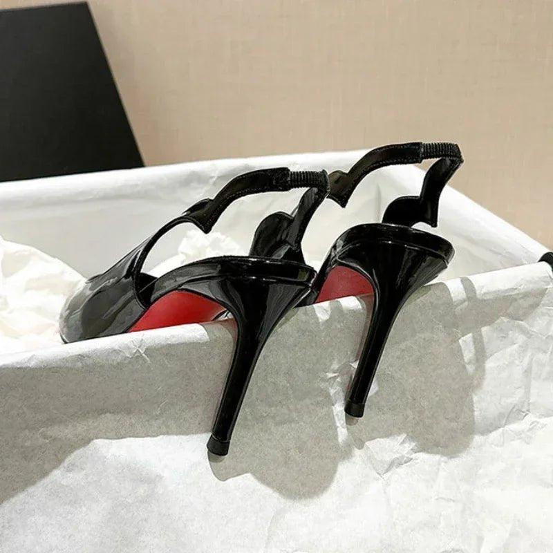 Black patent leather high heels with red soles, stylish women's fashion footwear in gift box
