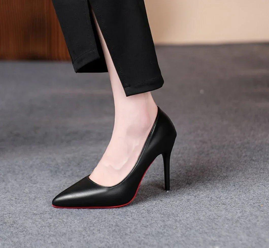 Black pointed-toe high heels with red sole, worn with black pants, women's fashion footwear