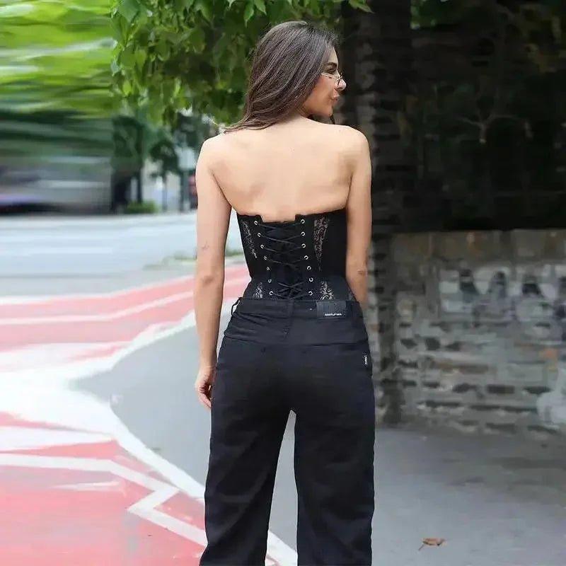 Woman in black lace-up corset top and wide-leg pants, street style fashion