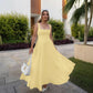 Woman in yellow square neck midi dress with white heels and handbag, outdoor fashion look
