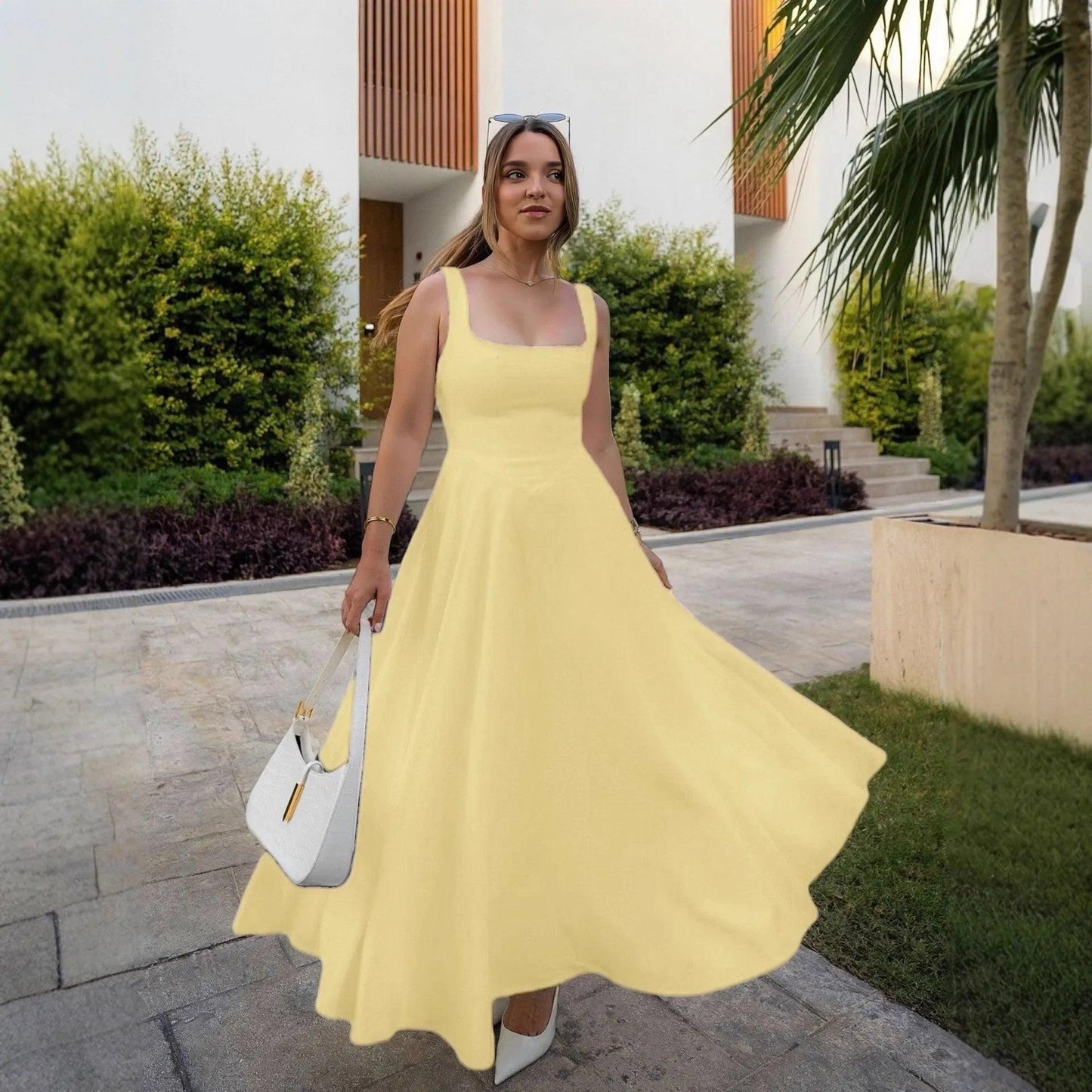 Woman in yellow square neck midi dress with white heels and handbag, outdoor fashion look