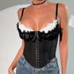 Black lace-up corset top with white lace trim and ruffles, paired with jeans for women's fashion