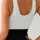 White sleeveless top with deep scoop back, paired with black high-waist skirt for women's fashion