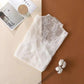 White lace women's fashion top with floral embroidery, styled with cotton buds and magazine