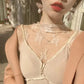 Woman wearing lace mesh top with floral embroidery, pearl earrings, and red lipstick for elegant fashion look
