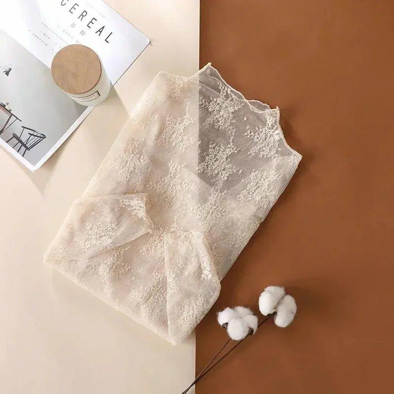Delicate lace women's blouse with floral pattern, soft cream color, styled with cotton buds and magazine