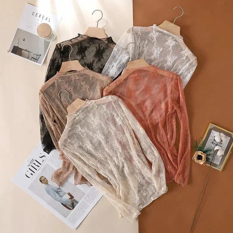 Women's lace long sleeve tops in black, white, beige, and pink, styled on hangers with fashion magazines