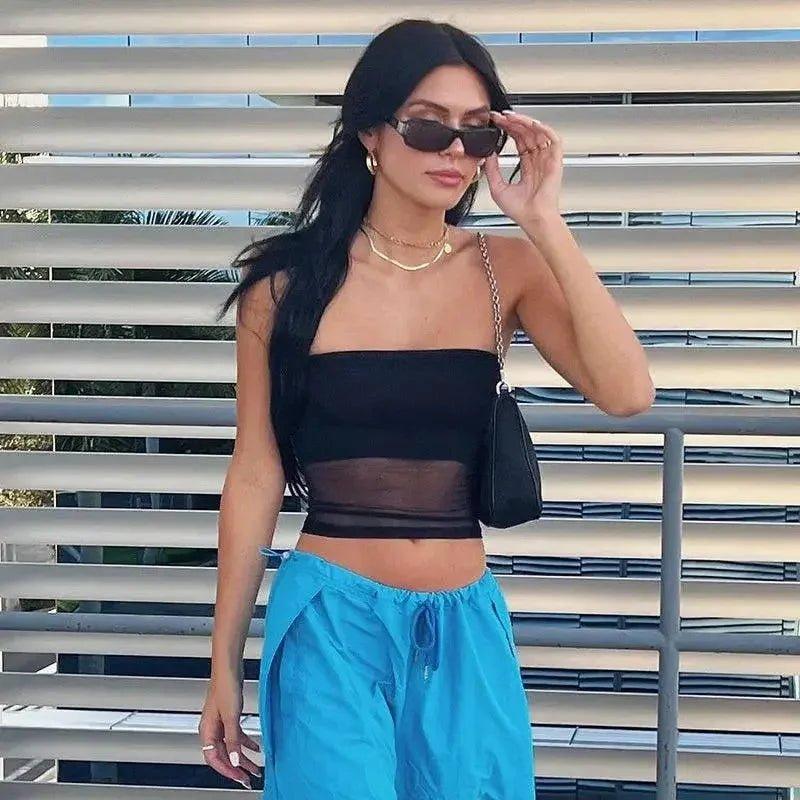 Woman in black crop top and blue pants, stylish summer fashion outfit with sunglasses and gold jewelry