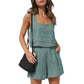 Woman in sage green linen two-piece set with square neck top and pleated shorts, carrying black woven bag