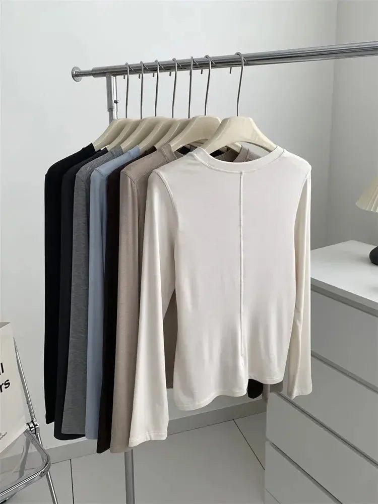 Women's long sleeve tops in neutral colors on clothing rack, fashion essentials for everyday wear