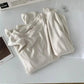 Cream women's long sleeve top styled with Paris magazine and earrings, minimalist fashion