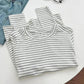 Striped women's t-shirt with denim shorts and black glasses on white table
