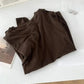 Brown women's fashion top with Paris magazine and earrings, stylish casual wear
