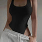 Black ribbed bodysuit with scoop neck, paired with gray sweatpants for casual women's fashion