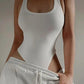 White ribbed bodysuit with side cutouts, paired with gray sweatpants, perfect for casual fashion