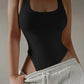 Black ribbed bodysuit with side cutouts, paired with gray sweatpants for casual women's fashion