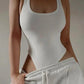 White ribbed bodysuit with side cutouts paired with gray sweatpants, women's fashion