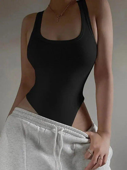 Black ribbed bodysuit with racerback, paired with gray sweatpants for casual fashion