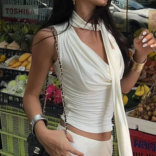 Woman in white ruched crop top with halter neck, shopping at outdoor fruit market, stylish summer fashion