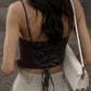 Woman wearing black lace-up crop top with white pants and handbag, back view fashion outfit