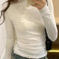 White long sleeve fitted top with ruched detail, paired with denim jeans for casual women's fashion