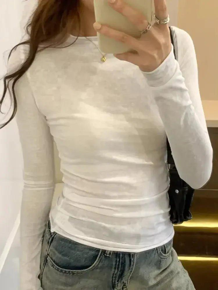 White long sleeve fitted top with ruched detail, paired with denim jeans for casual women's fashion
