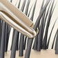 Gold hair straightener gliding through dark strands for sleek, smooth styling