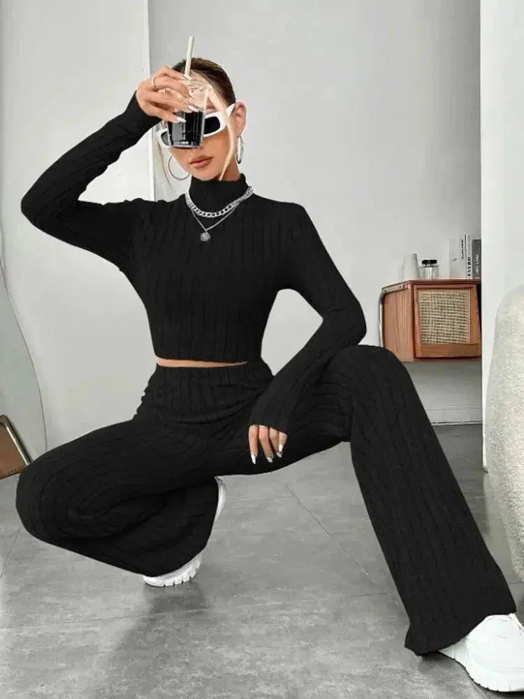 Woman in black ribbed knit crop top and wide-leg pants, stylish fashion outfit