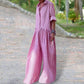 Woman in pink gingham jumpsuit with wide legs, walking outdoors on paved path