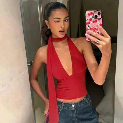 Woman in red halter top and jeans taking mirror selfie with cherry phone case